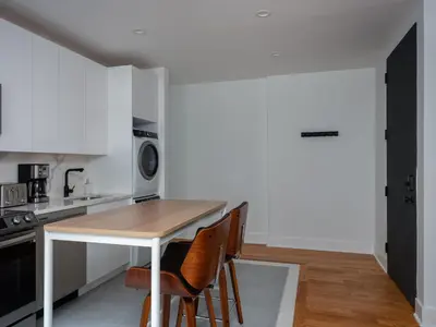 a kitchen with a wooden table and chairs at Three Bedroom Brooklynite Suite! in Brooklyn