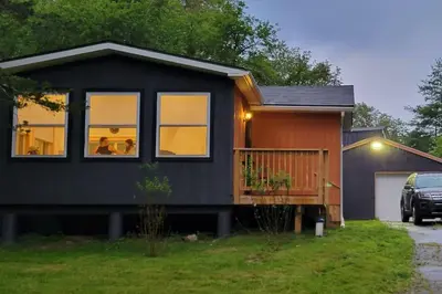 a black house with people sitting in the windows at Bethel Woods Cabin in Mongaup Valley