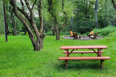 a picnic table and benches in a park at Bethel Woods Cabin in Mongaup Valley