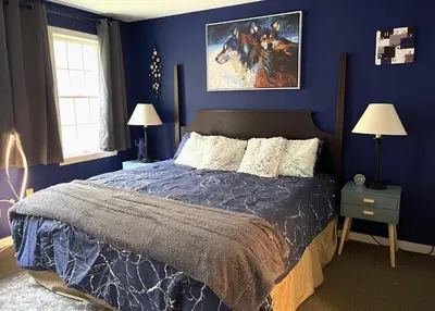 a bedroom with a bed with a blue wall at Mountain View Suite on Jiminy Peak Ski On Off -New in Hancock