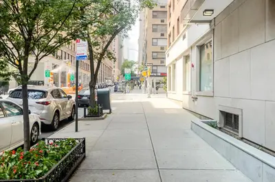 a sidewalk with cars parked on a city street at Midtown E 1BR w Gym Doorman nr the 6 NYC-4 in New York