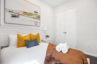 a bedroom with a bed with yellow and blue pillows at SWJ 5th - Perfect for Tourism: Near Train, Times Sq, Dining in New York
