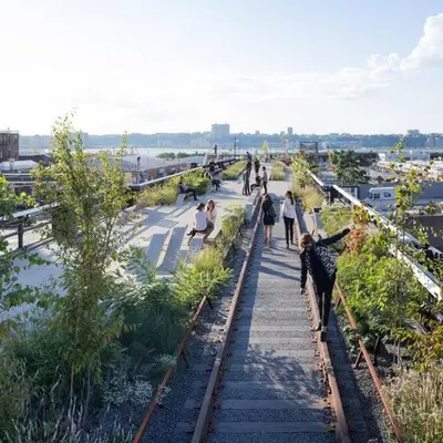 a group of people walking on a walkway next to train tracks at SWJ 5th - Perfect for Tourism: Near Train, Times Sq, Dining in New York