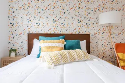 a bedroom with a white bed with a floral wallpaper at Double The Fun II Two Houses and fire pit in shared yard in Kingston