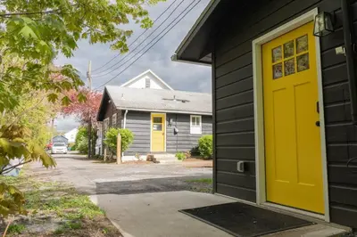 a yellow door on the side of a house at Double The Fun II Two Houses and fire pit in shared yard in Kingston