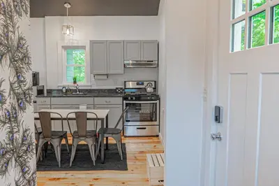 a kitchen with a table and a table and chairs at Double The Fun II Two Houses and fire pit in shared yard in Kingston