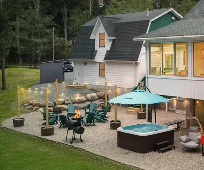 a backyard with a hot tub and chairs and a house at Luxuriously Restored Farm Cabin in Mountainhome