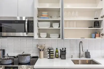 a kitchen with white cabinets and a sink at SWJ 4th and 5th - Save on 2Day+ Stays_Duplex in New York