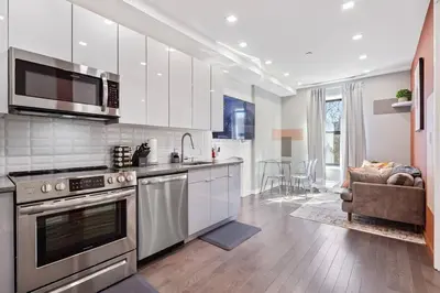 a kitchen with stainless steel appliances and a living room at SWJ 4th and 5th - Save on 2Day+ Stays_Duplex in New York