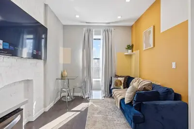a living room with a blue couch and a fireplace at SWJ 4th and 5th - Save on 2Day+ Stays_Duplex in New York