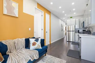 a living room with a blue couch and a kitchen at SWJ 4th and 5th - Save on 2Day+ Stays_Duplex in New York