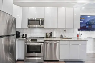 a kitchen with white cabinets and stainless steel appliances at SWJ 4th and 5th - Save on 2Day+ Stays_Duplex in New York