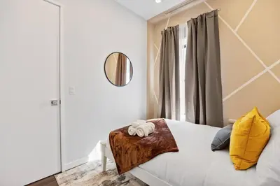 a bedroom with a bed with a mirror and a window at SWJ 4th and 5th - Save on 2Day+ Stays_Duplex in New York