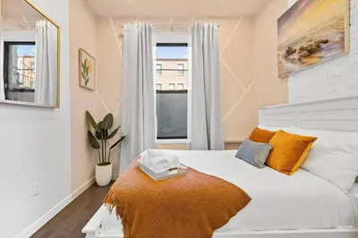 a bedroom with a white bed and a window at SWJ Btm G, 1 and 2 - Save on 2Day+ Stays_6Br Triplex in New York