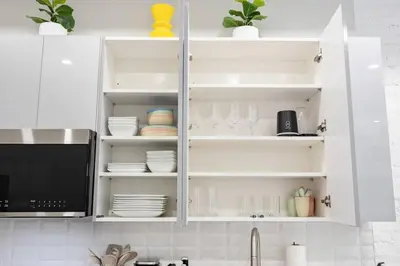 a kitchen with white cabinets with dishes and a microwave at SWJ Btm G, 1 and 2 - Save on 2Day+ Stays_6Br Triplex in New York
