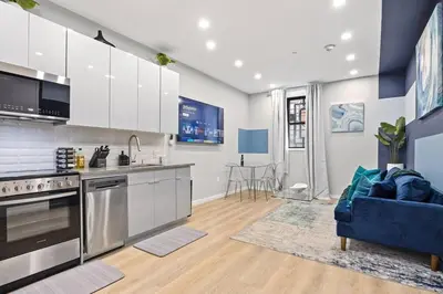 a kitchen with stainless steel appliances and a blue couch at SWJ Btm G, 1 and 2 - Save on 2Day+ Stays_6Br Triplex in New York