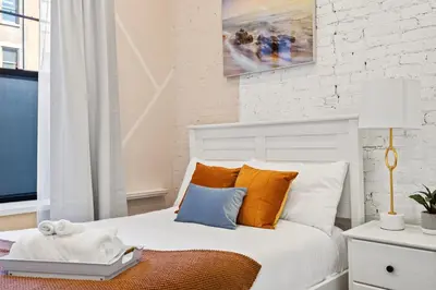 a bedroom with a bed with orange and blue pillows at SWJ Whole Bldg - Largest Place in NYC_21 Beds_6 apts in New York
