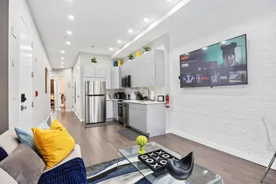 a living room with a couch and a tv on a wall at SWJ Whole Bldg - Largest Place in NYC_21 Beds_6 apts in New York