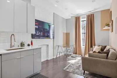 a kitchen and living room with white cabinets and a couch at SWJ Whole Bldg - Largest Place in NYC_21 Beds_6 apts in New York