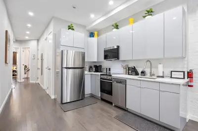a kitchen with white cabinets and a stainless steel refrigerator at SWJ Whole Bldg - Largest Place in NYC_21 Beds_6 apts in New York