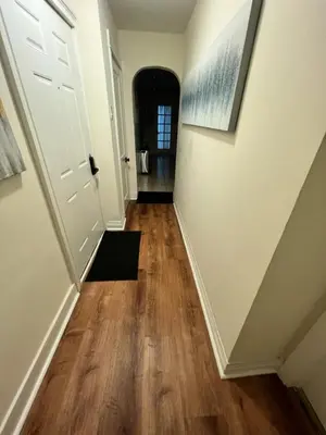 a hallway with white walls and wood floors at 8-A Diamond in Yonkers, NY in Yonkers
