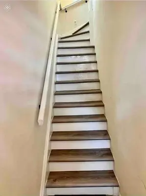 a staircase in a house with white walls and wooden floors at 8-A Diamond in Yonkers, NY in Yonkers