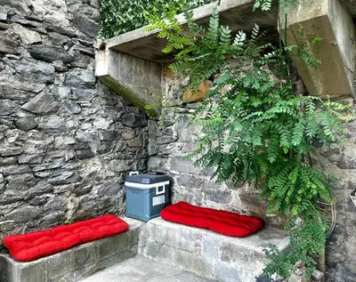 a stone wall with two red pillows and a trash can at 10-A Diamond in Yonkers, NY in Yonkers