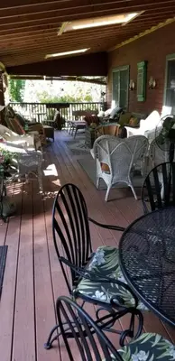 a deck with chairs and tables on a porch at Eastgate Inn B&B in Lenox