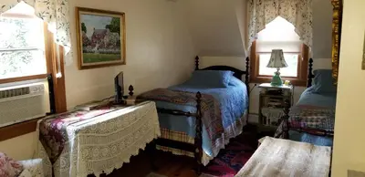 a bedroom with two beds and a window at Eastgate Inn B&B in Lenox