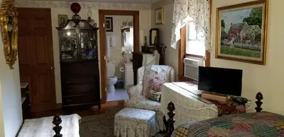 a living room with a tv and a couch and a chair at Eastgate Inn B&B in Lenox