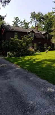 a house with a grass yard and a driveway at Eastgate Inn B&B in Lenox