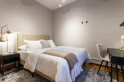 a white bedroom with a bed and a desk at Downtown New Haven, Spacious Stay by Yale - AO Destinations in New Haven