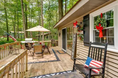 a deck with a table and chairs on a house at 1 Mi to Gouldsboro State Park Cabin with Deck! in Gouldsboro
