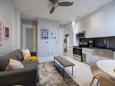 a living room with a couch and a kitchen at Cozy & Convenient Midtown Condo-Hotel! in New York
