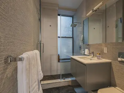 a bathroom with a sink and a shower at Cozy & Convenient Midtown Condo-Hotel! in New York