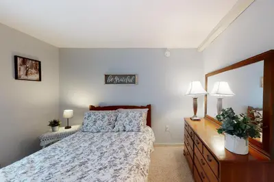 a bedroom with a bed and a dresser and a mirror at Gone Ski inn in West Dover