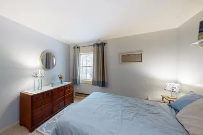 a bedroom with a bed and a dresser and a mirror at Gone Ski inn in West Dover