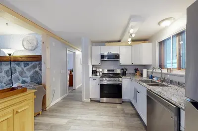 a kitchen with white cabinets and a stove top oven at Gone Ski inn in West Dover