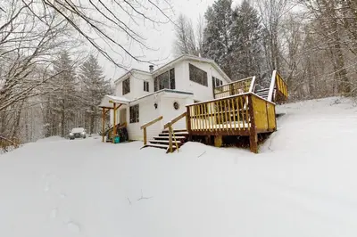 a house in the snow in the woods at Gone Ski inn in West Dover