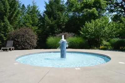 a fountain in a pool in a yard at Woodfield Manor - A Sundance Vacations Property in Cresco