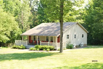 a white house with a gambrel roof at Woodfield Manor - A Sundance Vacations Property in Cresco
