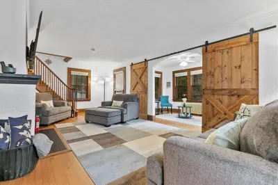 a living room with a fireplace and a sliding barn door at Quintessential Cozy Haven, Brooklawn Beauty in Bridgeport