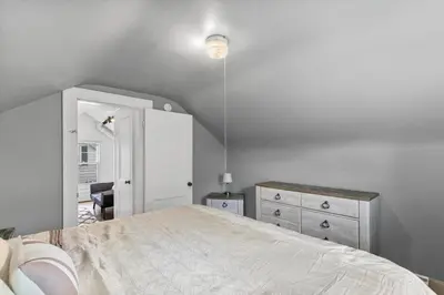 a white bedroom with a bed and a dresser at Quintessential Cozy Haven, Brooklawn Beauty in Bridgeport