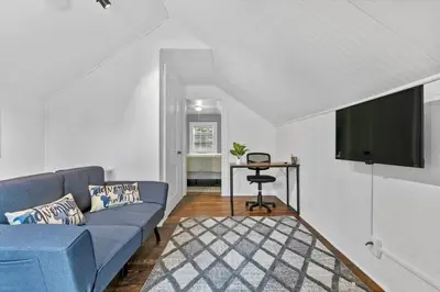 a living room with a blue couch and a flat screen tv at Quintessential Cozy Haven, Brooklawn Beauty in Bridgeport