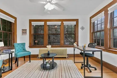 a room with two desks and two chairs and windows at Quintessential Cozy Haven, Brooklawn Beauty in Bridgeport