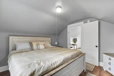 a bedroom with a large bed and a white cabinet at Quintessential Cozy Haven, Brooklawn Beauty in Bridgeport