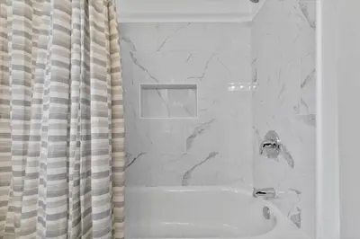 a bathroom with a shower with a tub and a shower curtain at Quintessential Cozy Haven, Brooklawn Beauty in Bridgeport