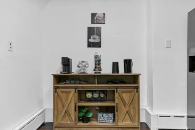 a wooden cabinet with doors in a room at Quintessential Cozy Haven, Brooklawn Beauty in Bridgeport