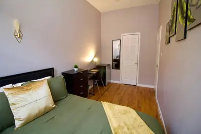 a bedroom with a green bed and a desk at Tuk Ahoy - Emerald Suite 2C with Shared Spaces in Brooklyn