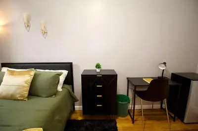 a bedroom with a bed and a desk with a desk at Tuk Ahoy - Emerald Suite 2C with Shared Spaces in Brooklyn
